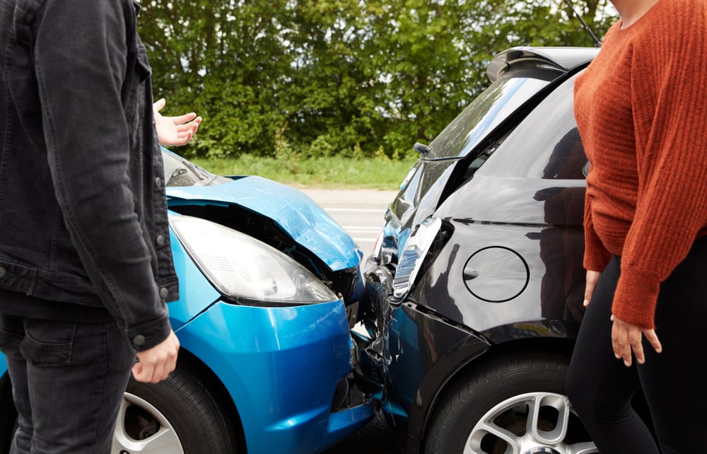 Frontal car crash of a blue and white hatchback