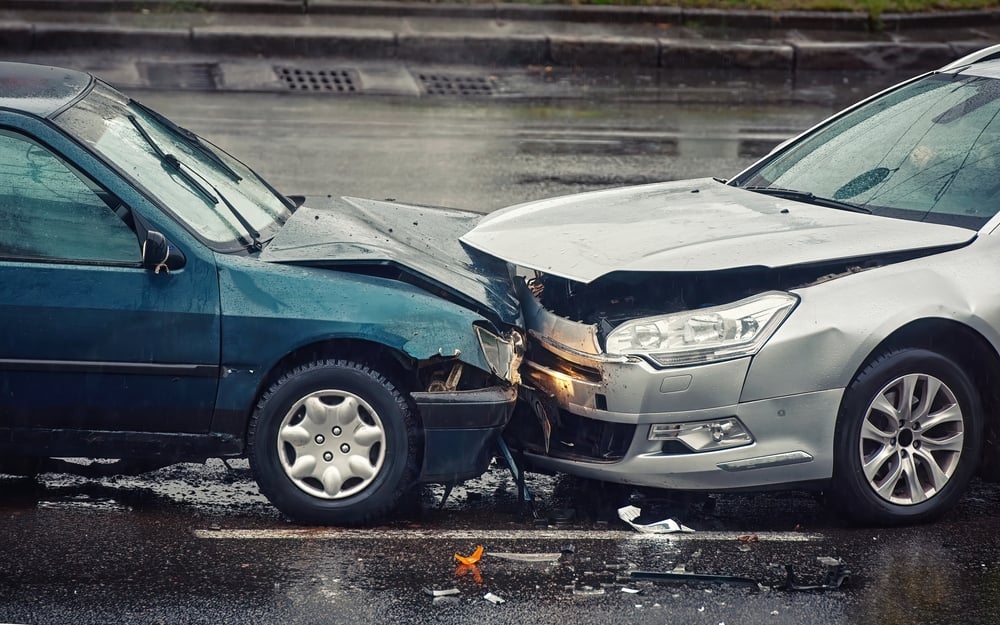 Frontal car crash of a blue and silver sedan