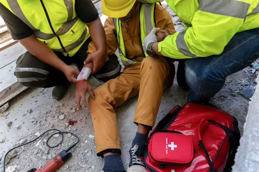 Construction workers helping a coworker after a construction accident