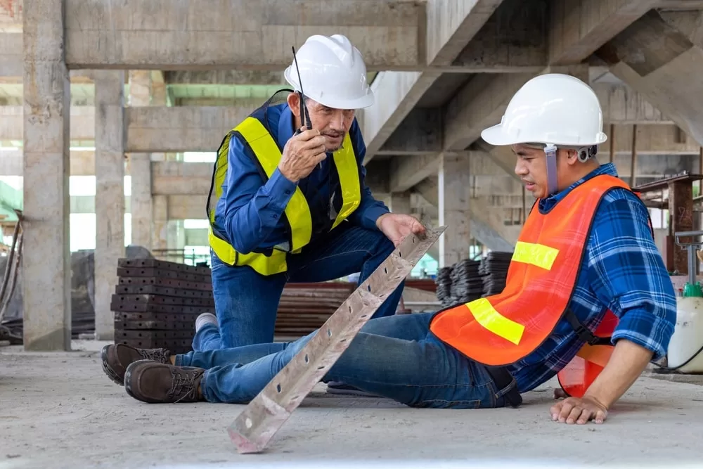 Construction worker helping a coworker after a construction accident