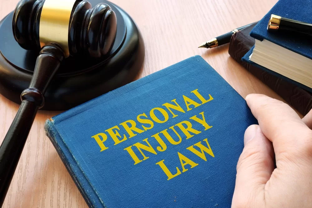 Personal injury law books on table with a gavel beside it