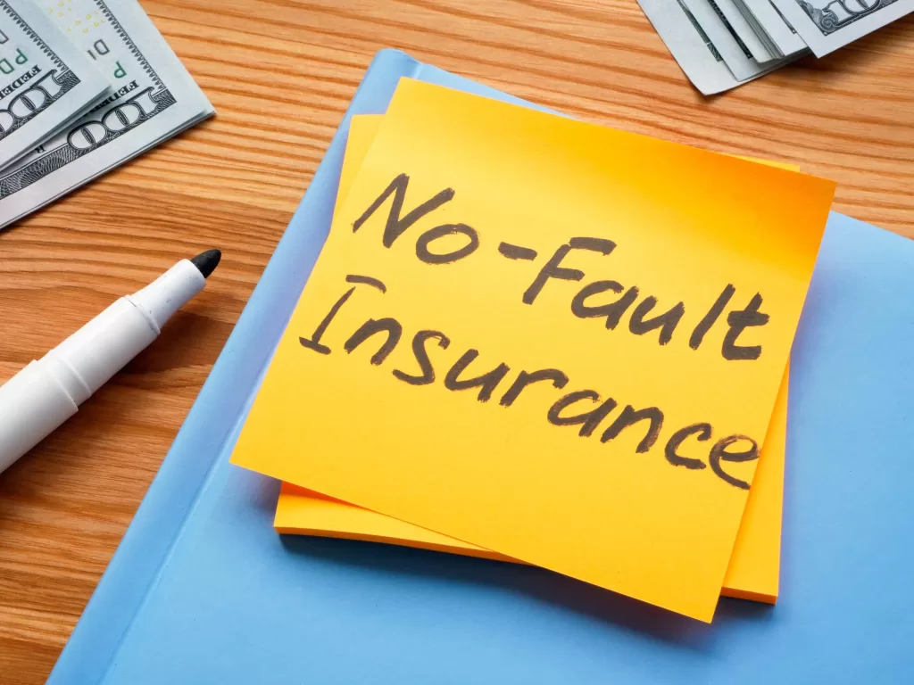 A Sticker with memo No fault insurance and notepad.