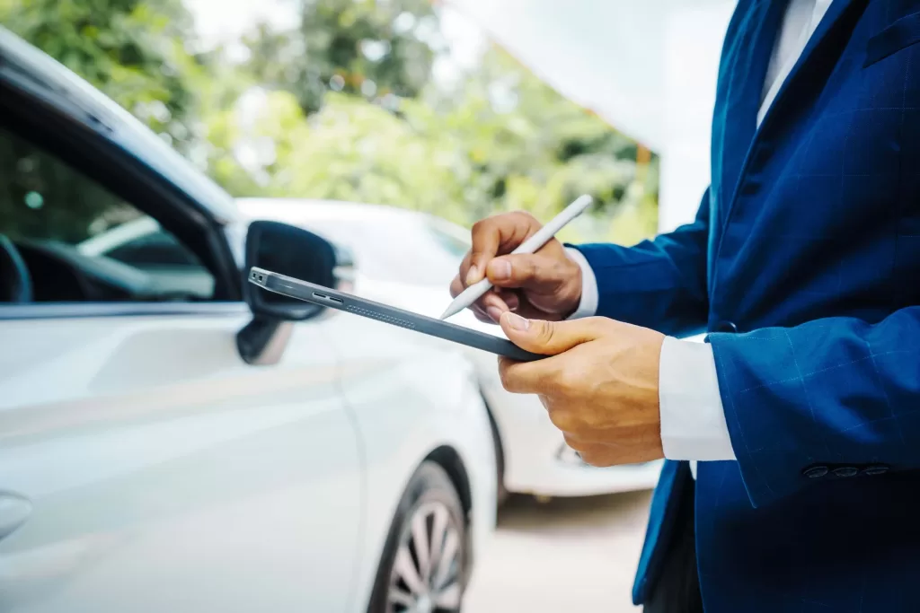 Insurance agent assess car damage