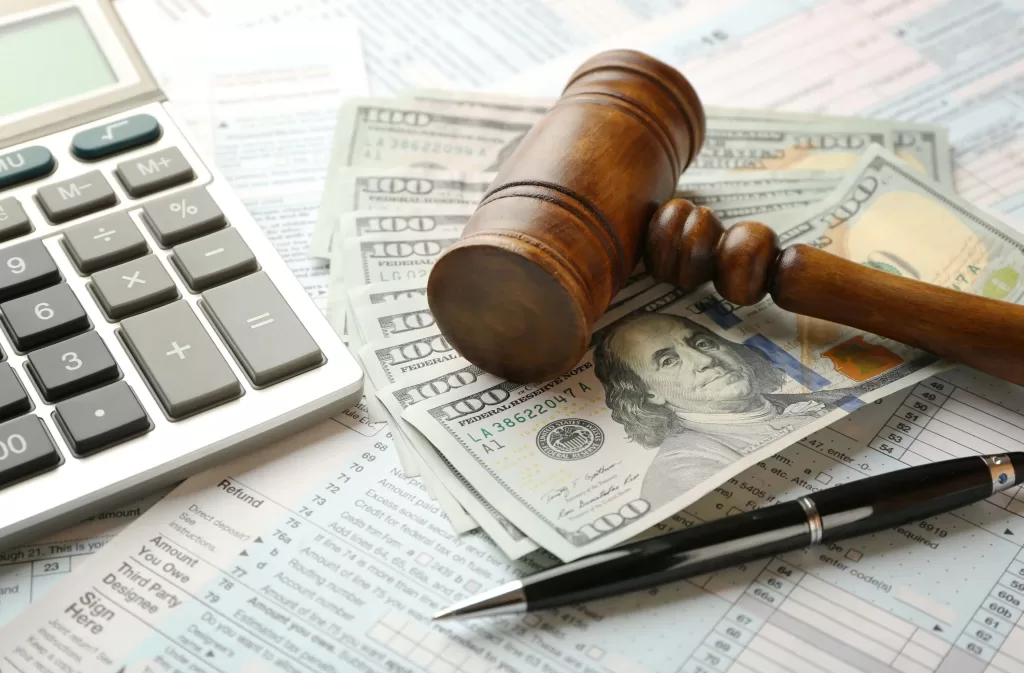 Judge's gavel and dollar banknotes on income tax form background